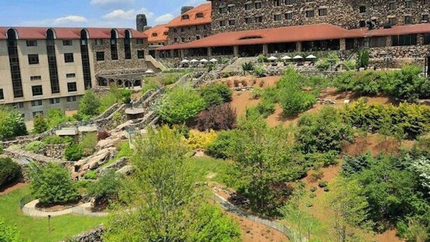 Un hôtel comprenant plusieurs bâtiments, un jardin aménagé et un sentier.
