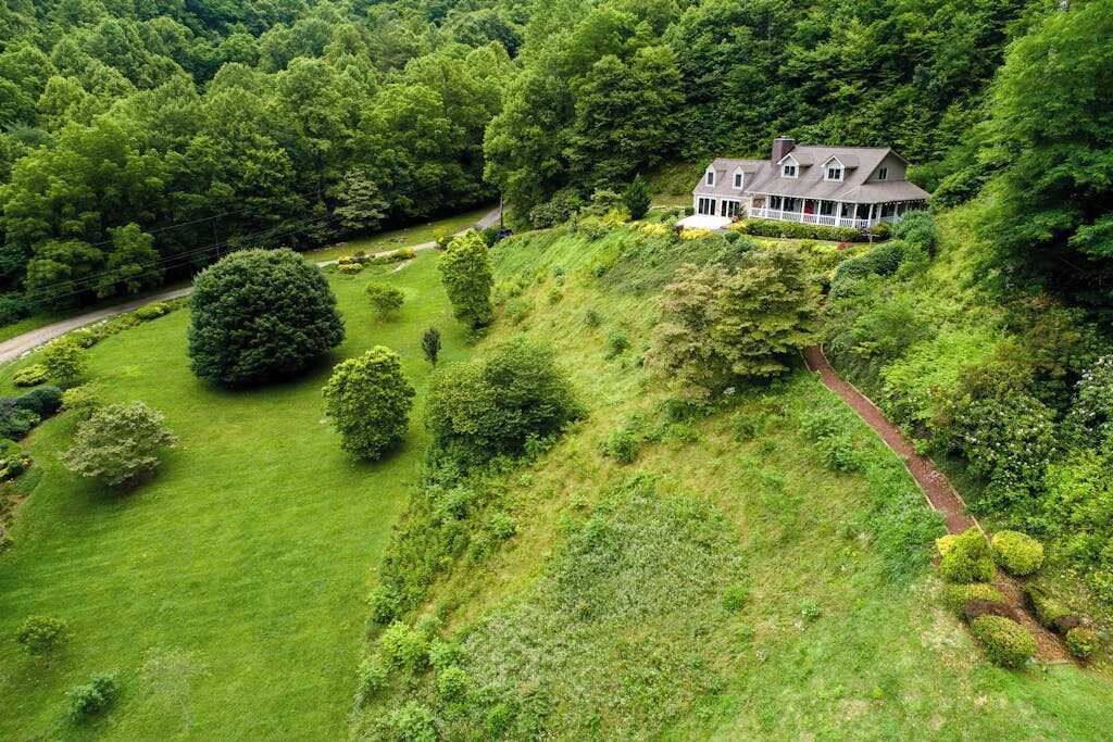 A large house surrounded by lush greenery and a winding path.