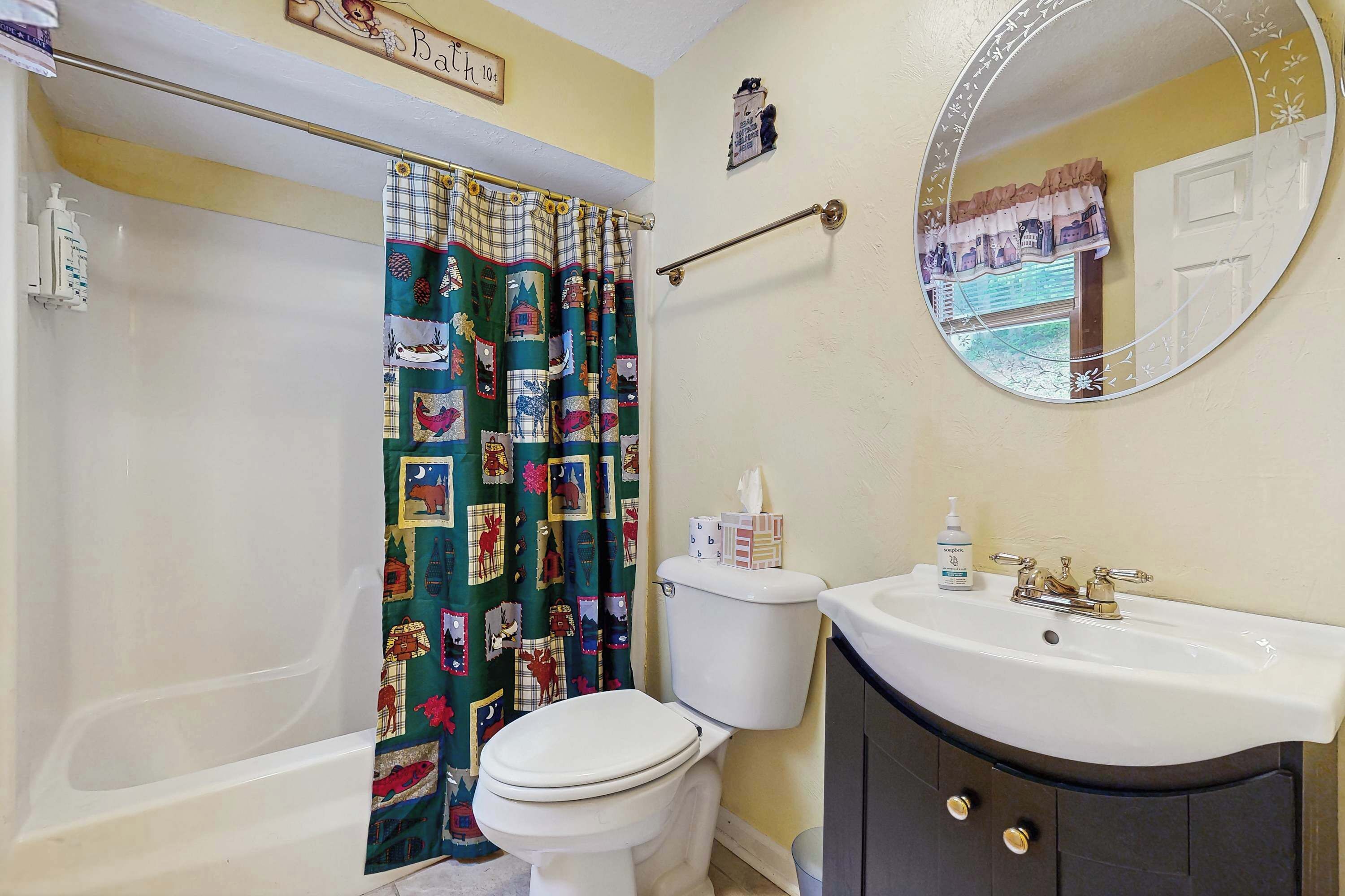 A bathroom with a bathtub, toilet, sink, and a mirror.