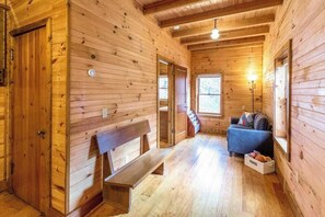 Ein Holzblockhaus-Innenraum mit einer Bank, einem Sofa und einem Fenster.