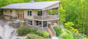 View-worthy home lined by trees with a fireplace, wrap-around deck, grill, & W/D