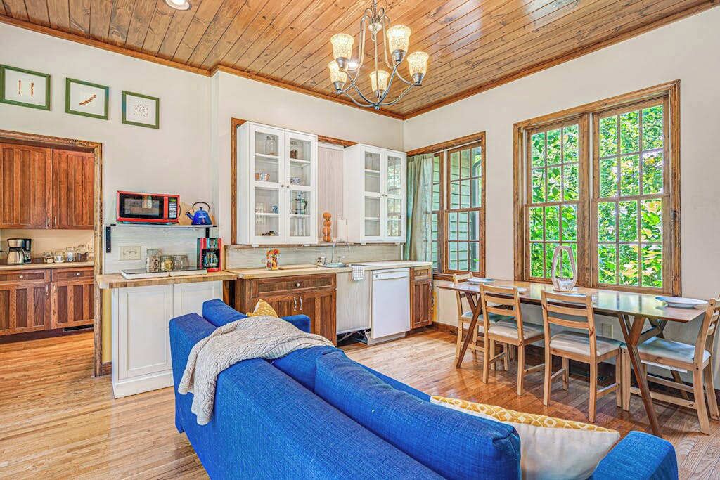 Eine Küche mit Holzausstattung, einer Mikrowelle und einem Essbereich mit Tisch und Stühlen.