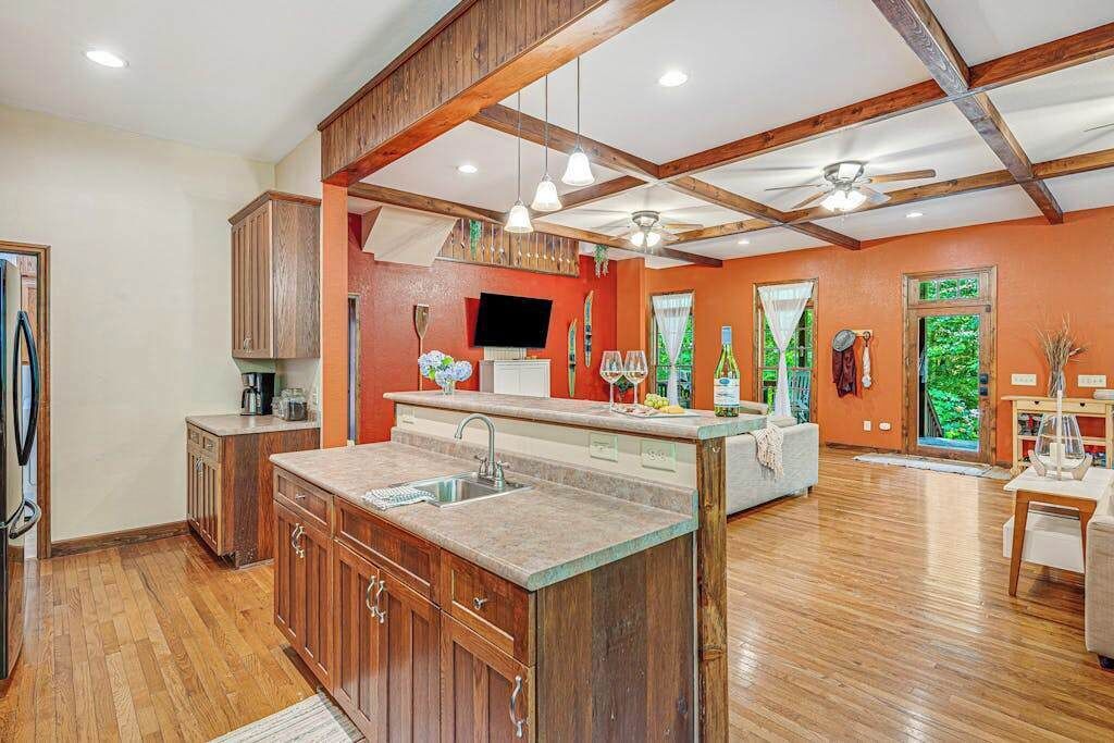 A spacious kitchen with wooden cabinets, a central island, and a dining area with a table and chairs.