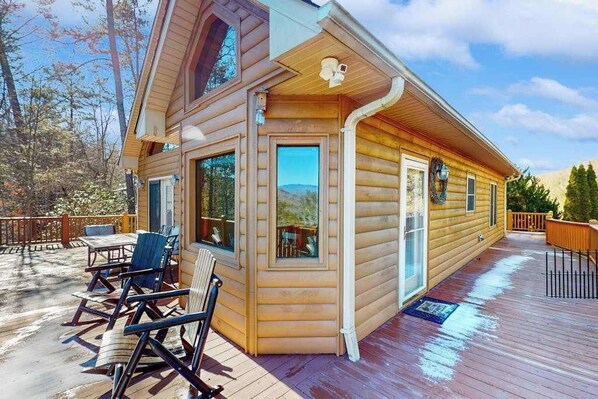 A log cabin with a deck, outdoor seating, and a mountain view. - Mountain Hideaway (Almond)