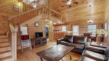 L’intérieur d’une cabane en bois comprend un salon, une cuisine et un escalier.