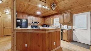 Ein Holzinterieur mit Kücheninsel, Holzausstattung und einer Tür.
