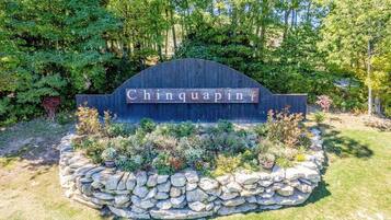 A stone wall with a sign reading 'Chinquapin' surrounded by a landscaped garden.