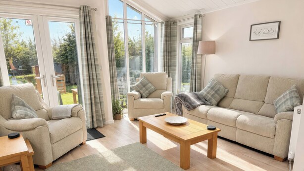 A living room with a sofa, armchairs, a coffee table, and a lamp. - Tiggywinkle Beck - White Cross Bay (Windermere)