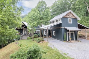 A two-story building with a covered porch and a gravel driveway. - Fabulous escape with firepit, stylish interior & central AC - near hiking (Waynesville)