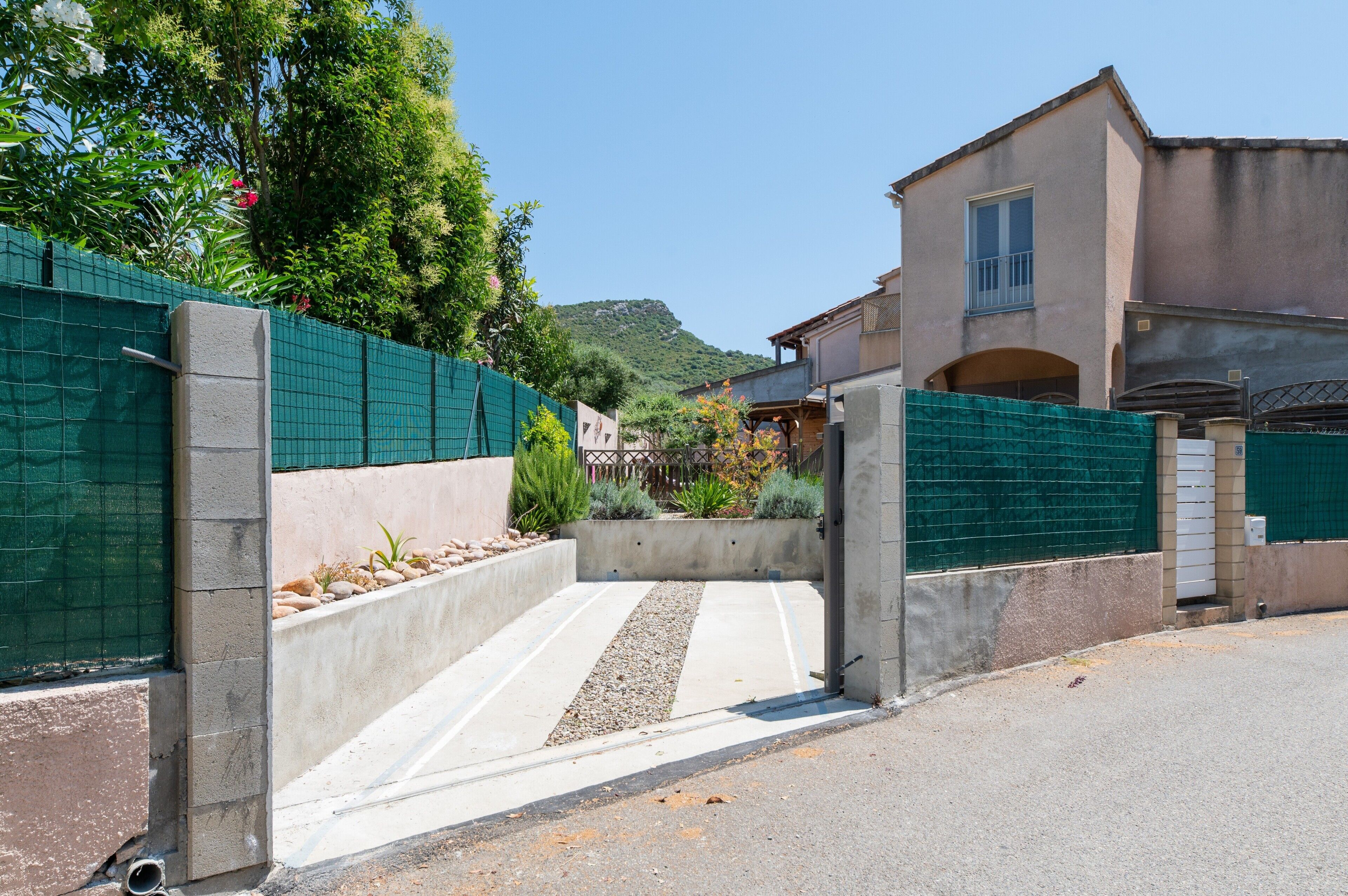 A gated entrance to a building with a concrete pathway leading to a door.