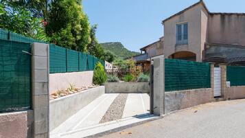 A gated entrance to a building with a concrete pathway leading to a door.