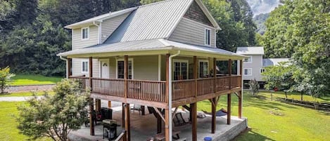 Ein zweistöckiges Haus mit Balkon, überdachter Veranda und Garten.