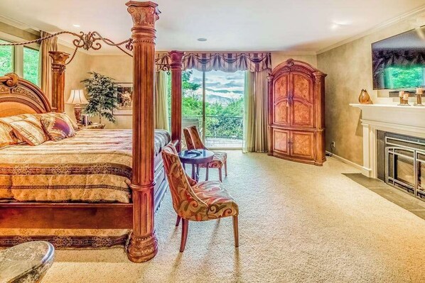 Una cama con dosel, una chimenea, un aparador de madera grande y una mesa de comedor con sillas en un dormitorio.