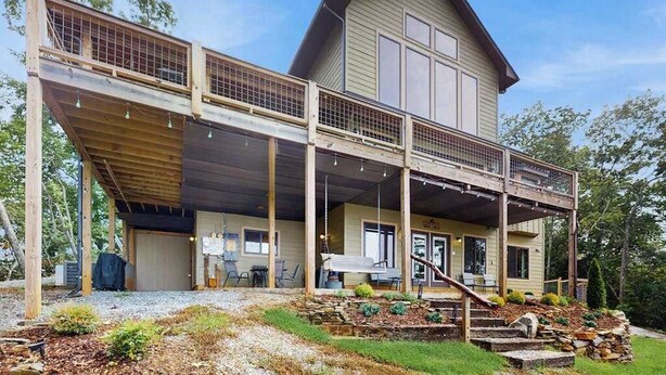 A two-story house with a covered porch, a garage, and a landscaped front yard. - The Ridge House (Franklin)