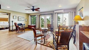 A spacious room with a bed, a desk, a chair, a table, and a ceiling fan. - The Ridge House (Franklin)