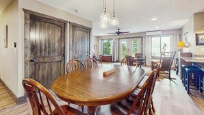 A spacious dining area with a large wooden table and chairs, a ceiling fan, and pendant lights. - The Ridge House (Franklin)