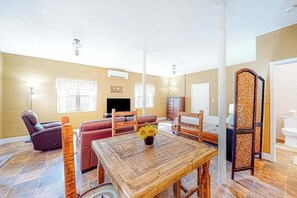A living room with a wooden table, sofas, a TV, and a fireplace. - Cozy Mountain Hideaway (Waynesville)