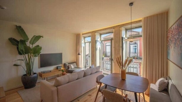 Un salon moderne avec un canapé, une table à manger et un téléviseur.