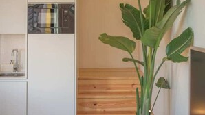 Une cuisine équipée d’un four à micro-ondes, d’un évier et d’un escalier en bois.