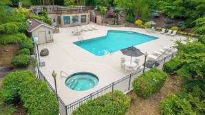 Una piscina con idromassaggio, sedie a sdraio e una zona relax coperta, il tutto immerso nel verde.