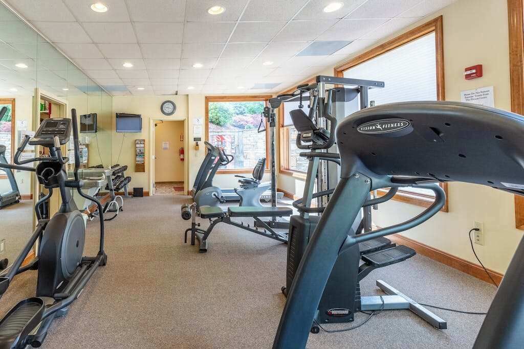A gym with treadmills, elliptical machines, and weight equipment.