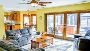 A living room with a sofa, coffee table, and a dining area with chairs. - Meadow Creek Manor (Whittier)