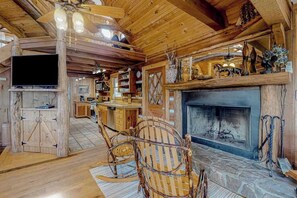 Ein rustikales Interieur mit Kamin, Holzmöbeln und einem Fernseher.
