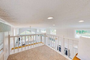 A spacious room with a high ceiling, large windows, and a view of the outdoors.