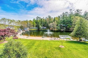 A serene lakeside property with a pond, a small dock, and a grassy area.