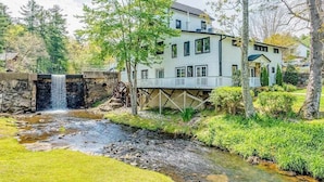 Una casa amb una petita cascada, un pont i un jardí ben cuidat.