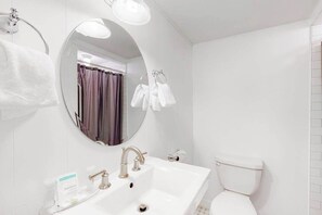 Ein Badezimmer mit Waschbecken, Toilette, Spiegel und Handtuchhalter.