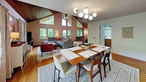 Un amplio salón con una mesa de comedor, un sofá y un ventilador de techo.