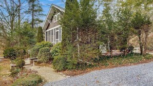 A house surrounded by dense forest, with a gravel driveway leading to the entrance. - Bearcat Cottage (Lake Junaluska)