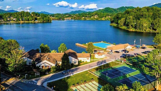 A lake with a tennis court, a swimming pool, and houses in the foreground. - Bearcat Cottage (Lake Junaluska)