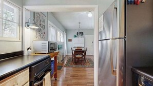 A kitchen with a refrigerator, microwave, and wooden cabinets. - Bearcat Cottage (Lake Junaluska)