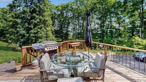 Eine Terrasse mit Tisch und Stühlen mit Glasplatte, umgeben von einem Holgitter.