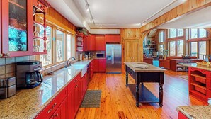 Una cocina amplia con armarios de madera, una isla central y un comedor.