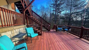 Eine Holzterrasse mit Außenmöbeln und einer Treppe zu einer erhöhten Ebene.