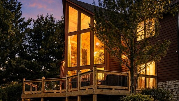 A modern house with a deck, outdoor seating, and a fire pit. - 4BR | Pool Table + Foosball | (Apple River)