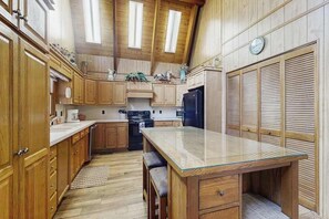 Eine Küche mit Holzschränken, einer Glasarbeitsplatte und einem eingebauten Backofen.