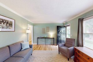Ein Wohnzimmer mit einer Couch, einem Sessel und einem Couchtisch.