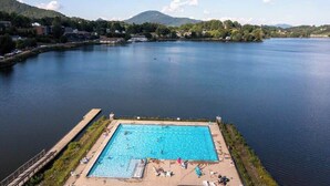 A swimming pool with a dock, surrounded by a lake and hills. - Hearthside at Lake Junaluska (Lake Junaluska)
