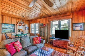 A wooden-paneled room with a sofa, television, and a chessboard. - Hearthside at Lake Junaluska (Lake Junaluska)