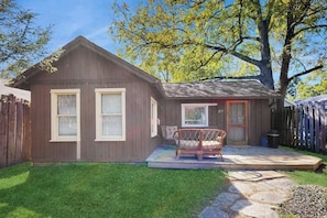 A small wooden house with a porch, a window, and a door. - Charming Brevard cottage perfect for a getaway with local shops & breweries! (Brevard)