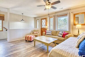 Ein Zimmer mit Deckenventilator, einer Couch, einem Couchtisch und einem Bett.