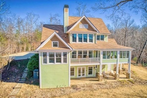 A two-story house with a balcony, a chimney, and a covered porch area. - Lakeview retreat with Free Wifi, hot tub, fireplaces, patio, balcony, & grill (Mill Spring)