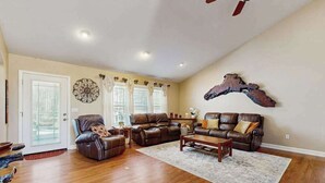 Un salon spacieux avec un canapé en cuir marron, un fauteuil inclinable et une table basse.