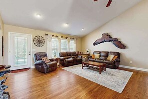 A spacious living room with a brown leather sofa, a recliner, and a coffee table. - Mountain Ranch Home w/ Pool Table, Fire Pit & Porch Rockers (Hendersonville)