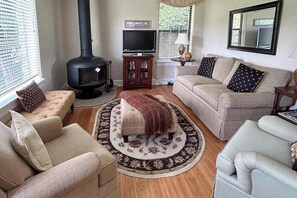Ein Wohnzimmer mit Kamin, Sofa und Fernseher.