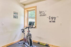 Ein Zimmer mit einem Fahrradergometer, einem Fenster und motivierenden Wandbildern.